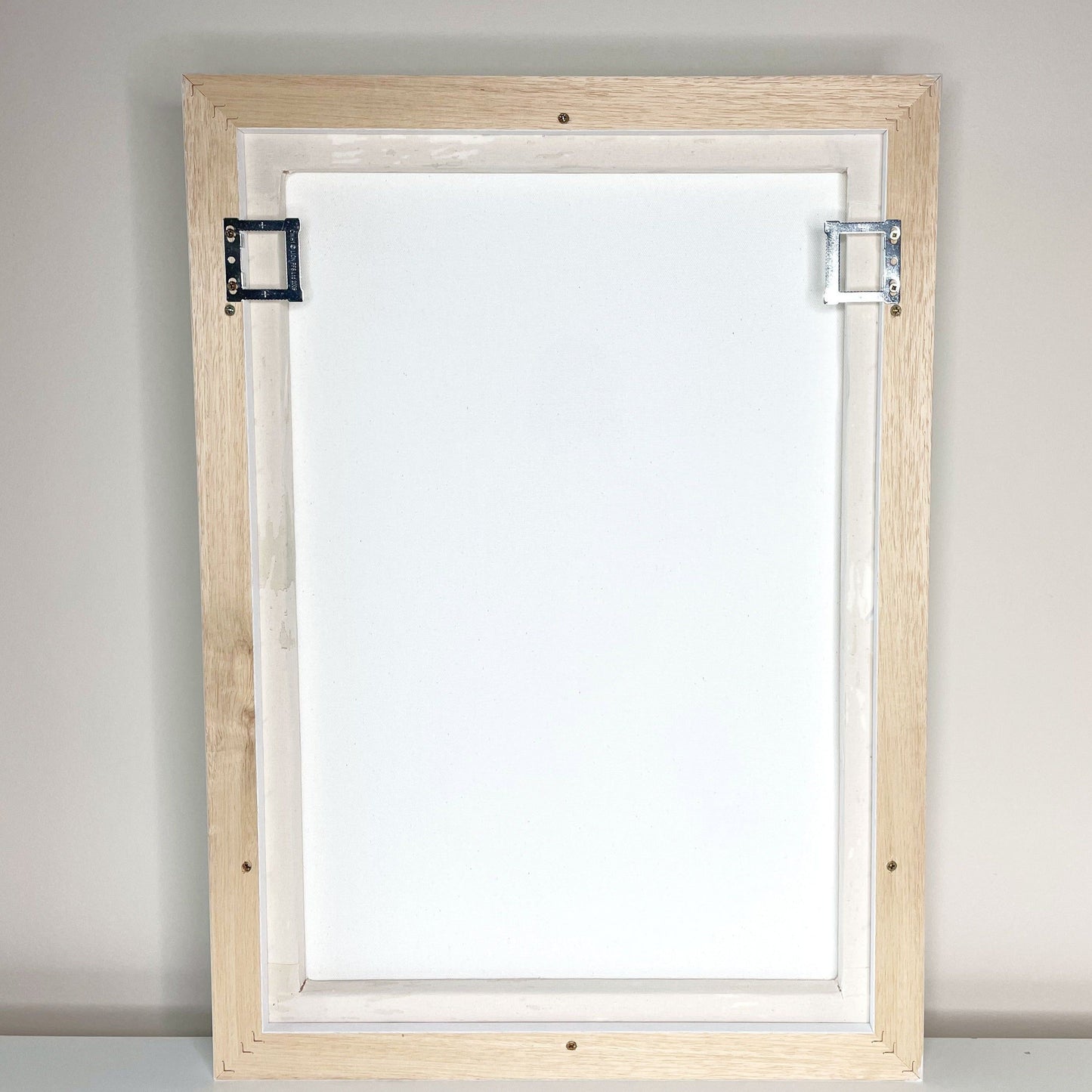 The back view of the canvas frame to show the fixes to hang on the wall