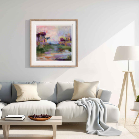 Living room with a gray sofa, coffee table, and framed artwork on the wall.