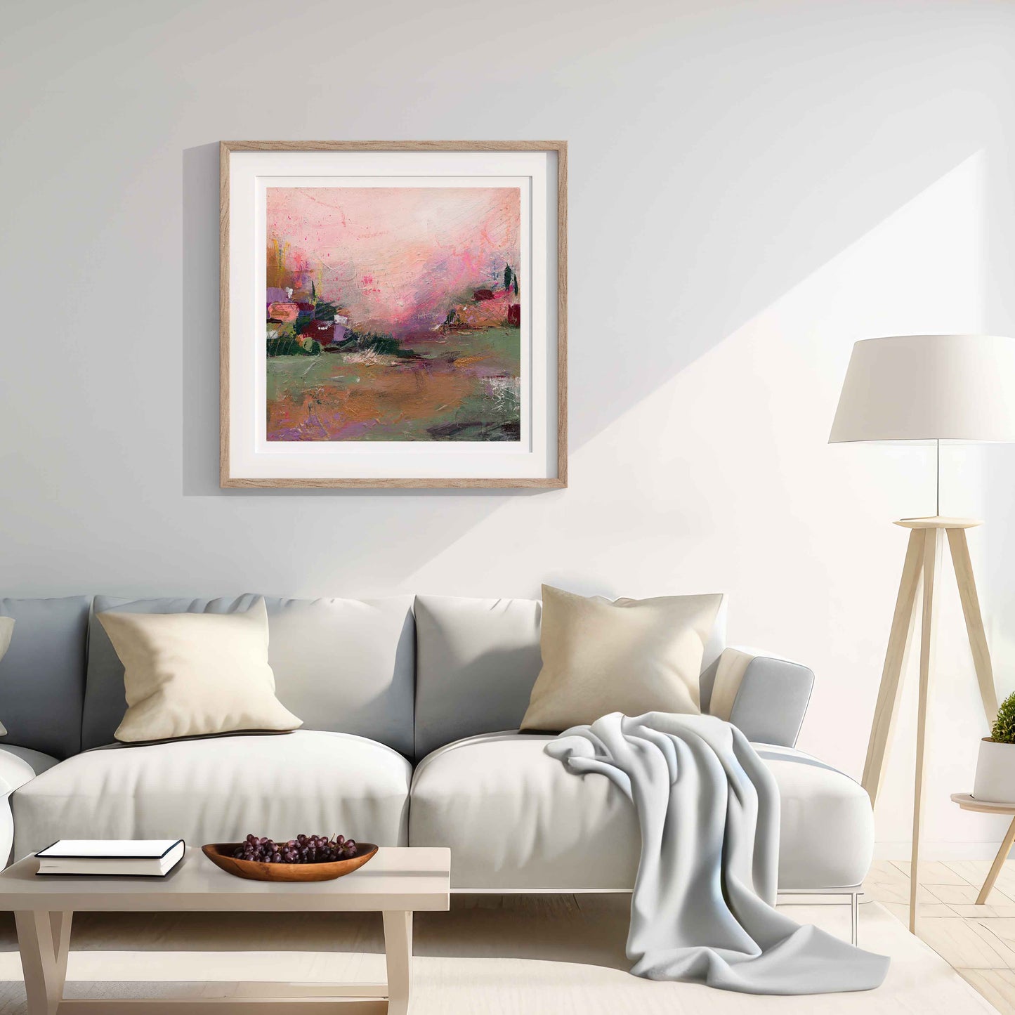 Living room with a gray sofa, framed art print, and lamp.