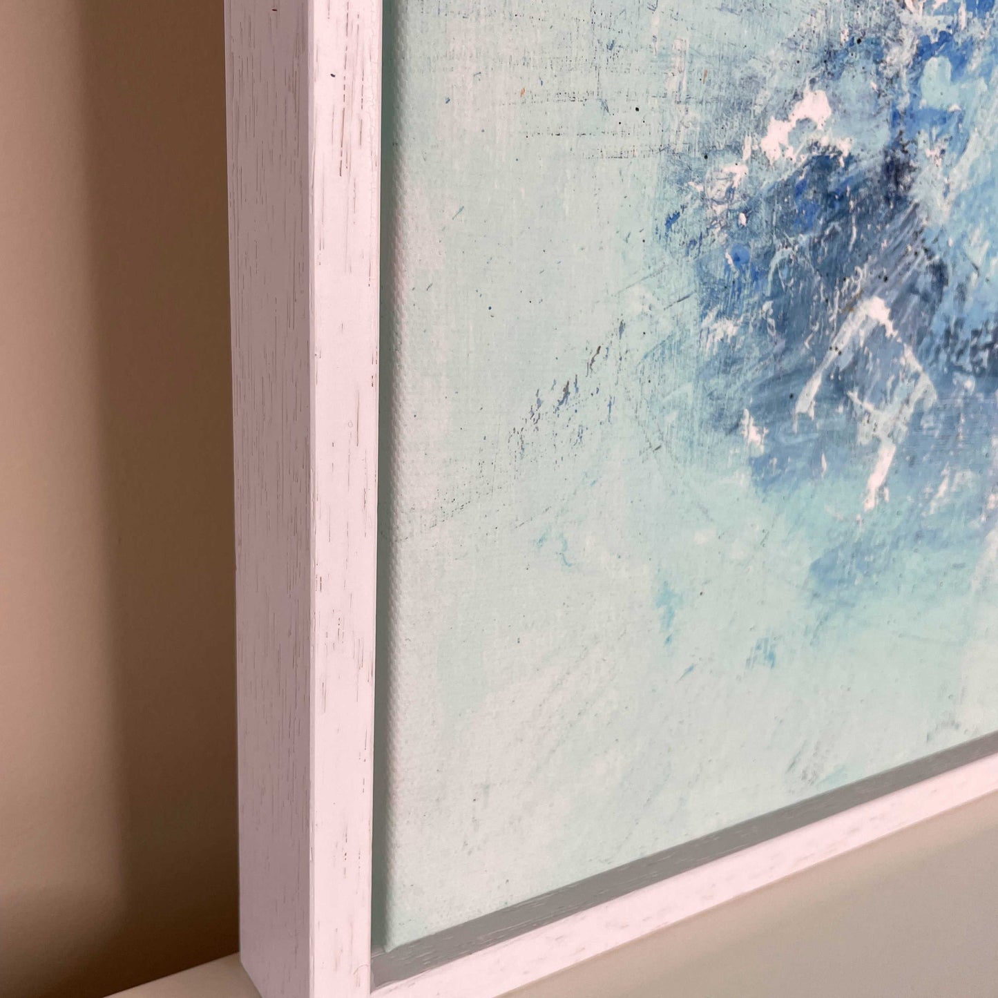A close up of the canvas and frame on the Print of an acrylic painting of a ballerina painted in blue.